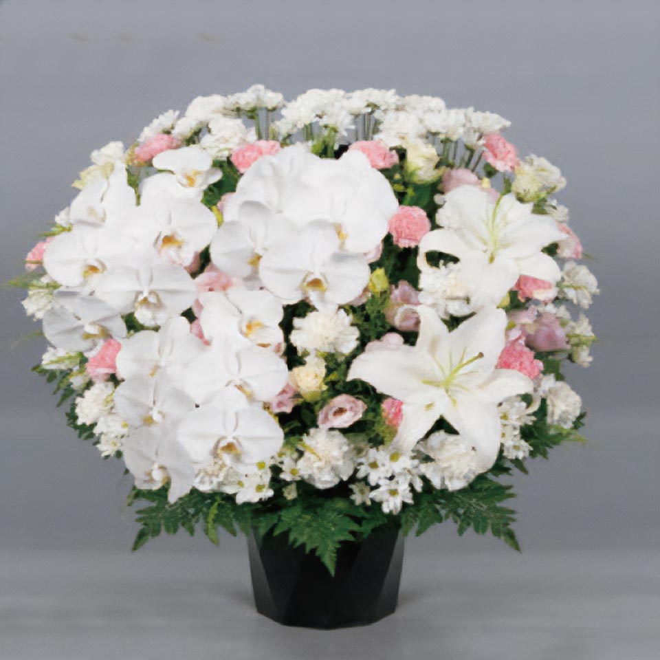白やピンクなどの花と緑の葉で作られた追悼の供花