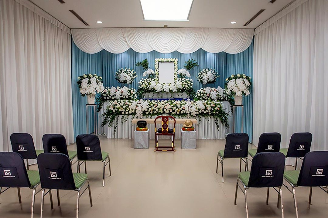 白を基調とした花で作られた祭壇があり、手前には参列者用のたくさんの椅子が並んでいます